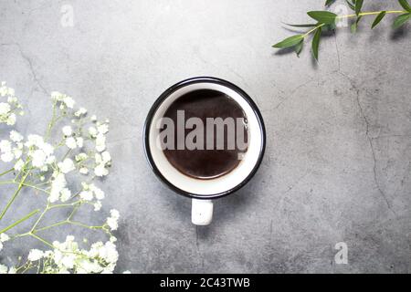 Tasse à café et fleurs printanières sur fond gris Banque D'Images