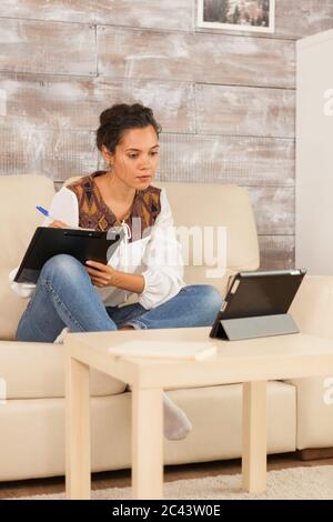 Femme indépendante réussie travaillant à domicile lors d'un appel vidéo avec des partenaires commerciaux. Banque D'Images