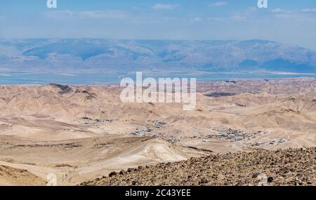 Un groupe de villages bédouins peut être vu dans les collines entre Arad en Israël et la mer Morte avec les montagnes Moab de jordanie en arrière-plan Banque D'Images