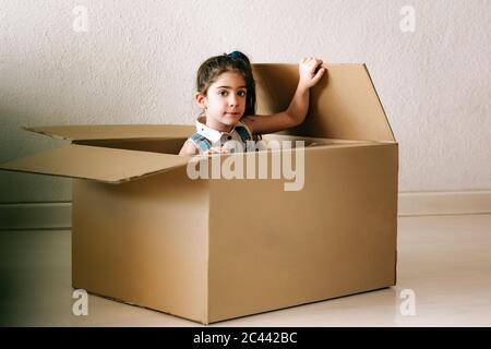 Portrait d'une petite fille à l'intérieur d'une boîte en carton Banque D'Images