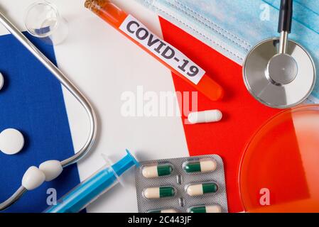 Coronavirus, le concept COVid-19. Top vue masque de protection respiratoire, stéthoscope, seringue, pilules sur le drapeau de la France. Une nouvelle épidémie des Chines Banque D'Images