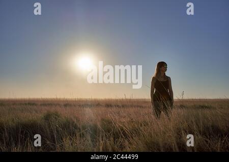 Femme debout sur le terrain contre ciel lors de journée ensoleillée, Makgadikgadi Pans, Botswana Banque D'Images