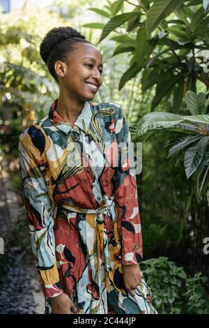 Portrait de jeune femme à la mode debout dans le jardin Banque D'Images