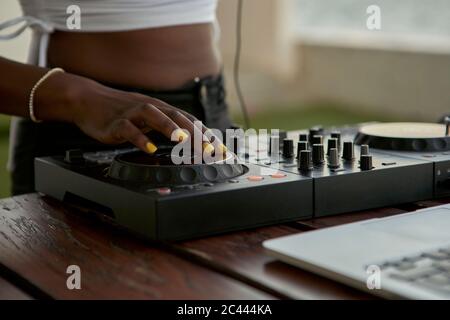 Vue rognée de DJane travaillant sur le plateau de mixage Banque D'Images