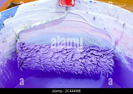 brosse rotative en fût en plastique blanc avec peinture violette, gros plan, dans le salon vide Banque D'Images