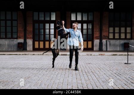 Homme jouant avec son chien à l'extérieur Banque D'Images