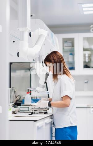 Scientifique mature utilisant l'équipement tout en travaillant au bureau en laboratoire Banque D'Images