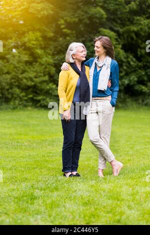 Bonne femme âgée et fille adulte debout sur un pré dans un parc qui se regarde l'une l'autre Banque D'Images