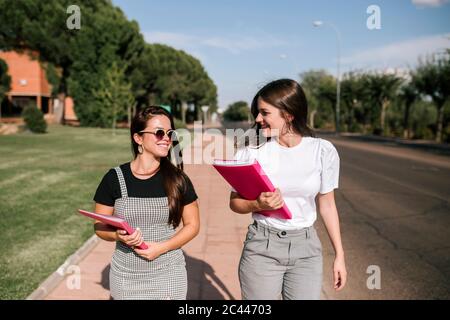 Les étudiantes et étudiants de l'université sont heureux de parler en marchant sur le sentier du campus par beau temps Banque D'Images