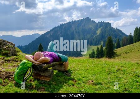 Allemagne, Bavière, Berlin, Male hiker prendre pause sur banc à Allgau Alpes Banque D'Images