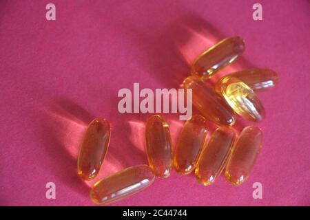 Capsules d'huile de poisson sur fond rose. Concept de santé Banque D'Images