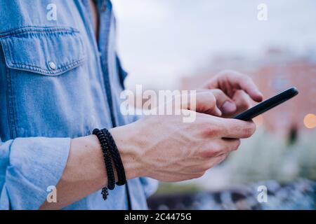 Main de l'homme tenant le smartphone, gros plan Banque D'Images