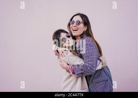 Portrait de deux jeunes femmes heureux qui s'embrasent Banque D'Images