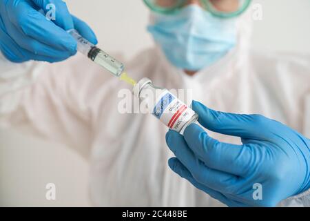 Femme en port de protection préparant la vaccination contre le covid-19 Banque D'Images