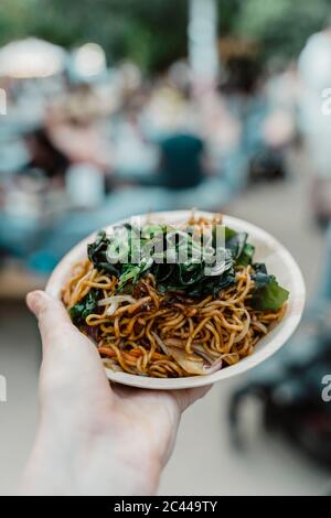 Portrait de femme tenant à la main dans un bol de nouilles fraîches au restaurant Banque D'Images