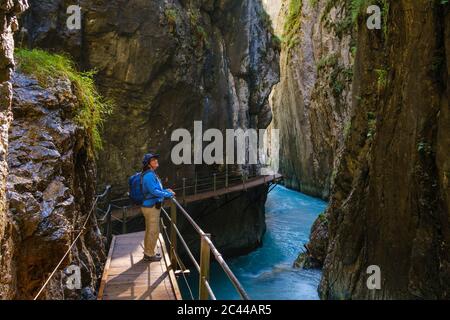 Vue latérale du senior woman standing sur passerelle à Wasserfallsteig Gorge à Leutasch, Tyrol, Autriche Banque D'Images