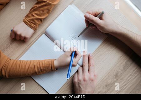 Vue de dessus de père et fils criant dans le carnet sur la table Banque D'Images