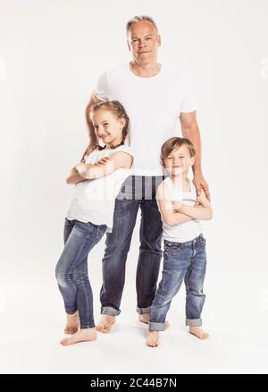 Portrait du père avec deux enfants debout devant un fond blanc Banque D'Images