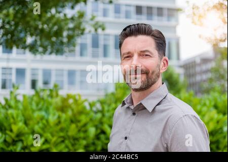 Portrait d'un homme d'affaires souriant et beau barbu dans le quartier financier Banque D'Images