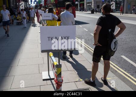 Les clients font la queue pour le magasin TK Max sur Oxford Street à Londres, le jour où le Premier Ministre britannique, Boris Johnson, a annoncé au Parlement un assouplissement majeur des restrictions de pandémie de coronavirus le 4 juillet prochain, y compris la réouverture de pubs, restaurants, hôtels et coiffeurs en Angleterre, le 23 juin 2020, À Londres, en Angleterre. La distance sociale de trois mois de deux mètres sera également réduite à un mètre plus mais au cours des 24 dernières heures, 171 autres sont morts de Covid, ce qui porte le total britannique à 42,927. Banque D'Images