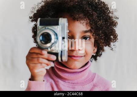 Portrait d'une petite fille souriante avec un appareil photo vintage Banque D'Images