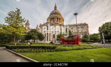 Vue sur la cathédrale St-Paul dans le centre de Londres le matin. Un bus rouge peut être vu passer. Banque D'Images