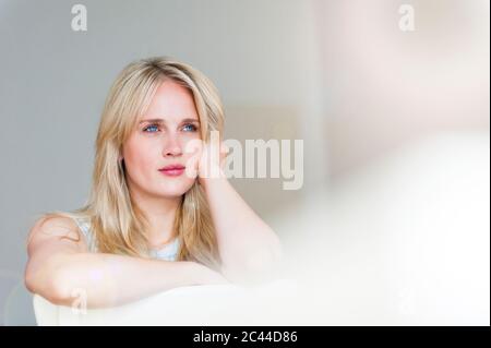 Portrait de femme blonde pensive avec les yeux bleus pensifs sur le dos Banque D'Images