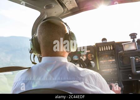 Pilote volant dans un avion sportif, carte VFR sur ses genoux Banque D'Images