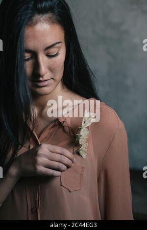 Belle jeune femme insérant des fleurs dans la poche Banque D'Images