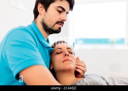 Physiothérapeute malvoyants traitant la femme en clinique Banque D'Images