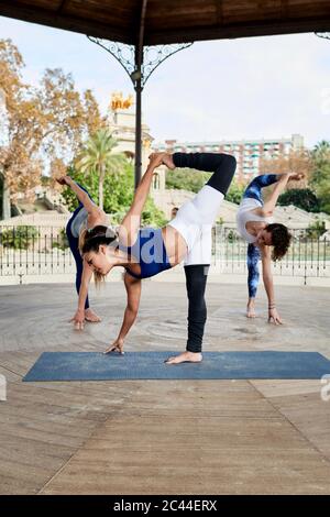 Une enseignante pratiquant le yoga avec un homme et une femme dans un belvédère au parc de la Ciutadella Banque D'Images