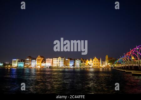 Bâtiments éclairés par la mer contre ciel clair la nuit à Willemstad, Curaçao Banque D'Images