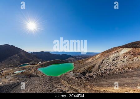 Nouvelle Zélande, île du Nord, soleil qui brille au-dessus des eaux vert émeraude au Parc National de Tongariro Banque D'Images