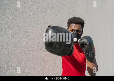 Portrait d'un sportif portant un masque facial et une boxe Banque D'Images