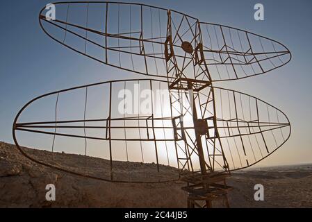 Gros plan de l'ancienne antenne radar militaire abandonnée dans un paysage désertique africain isolé avec coucher de soleil Banque D'Images