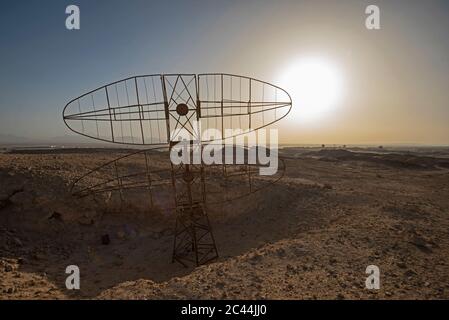 Gros plan de l'ancienne antenne radar militaire abandonnée dans un paysage désertique africain isolé avec coucher de soleil Banque D'Images