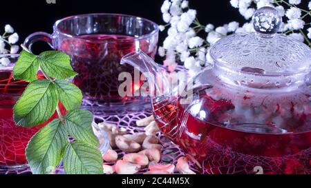 Thé rouge hibiscus chaud dans une tasse en verre. Temps de thé : tasse de thé, carcade, karting, rooibos. Oriental, confortable, cérémonie, tradition, japonais, verdoyant, hygge, Autum Banque D'Images