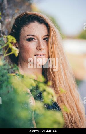 Portrait de belle jeune femme blonde avec des taches de rousseur sur le visage debout à l'extérieur Banque D'Images