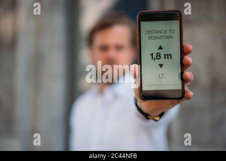 Gros plan sur un homme tenant un smartphone montrant la distance affichée Banque D'Images