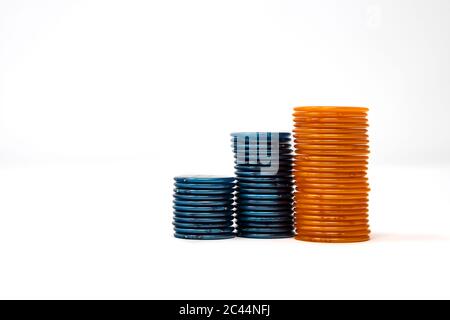 Pile de puces, isolée sur fond blanc. Couleurs : orange, bleu. Paris, gagner et perdre au jeu. Jouer au poker avec des fiches. Banque D'Images