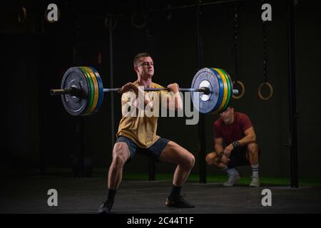 Homme faisant un exercice de squat au gymnase Banque D'Images