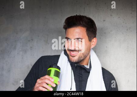 Portrait d'un jeune homme souriant ayant une pause de l'entraînement Banque D'Images