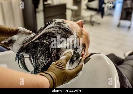 Femme au salon de coiffure se laver les cheveux avec des brosses Banque D'Images