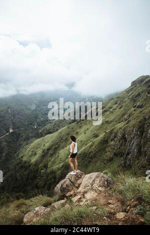 Sri Lanka, province d'Uva, Ella, randonneur femelle debout sur un rocher à Little Adams Peak Banque D'Images