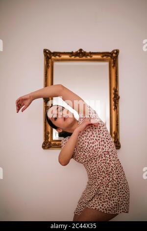 Ballerine dansant contre un miroir classique sur le mur à la maison Banque D'Images