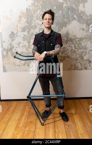 Portrait de femme percée et tatouée avec cadre de vélo Banque D'Images