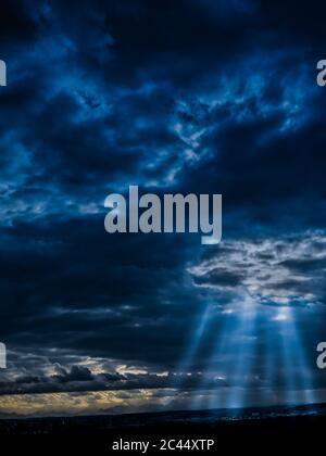 Lumière du soleil perçant à travers les nuages de tempête sombre Banque D'Images