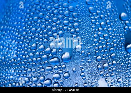 Macro Capture des gouttes d'eau bleues délicates sur une surface en verre Banque D'Images