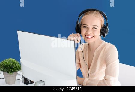 Conseiller souriant du service d'assistance avec casque parlant au client au centre d'appels, espace vide Banque D'Images