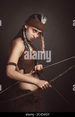 Guerrier sauvage natif avec arc et flèche. Prise de vue en studio Banque D'Images